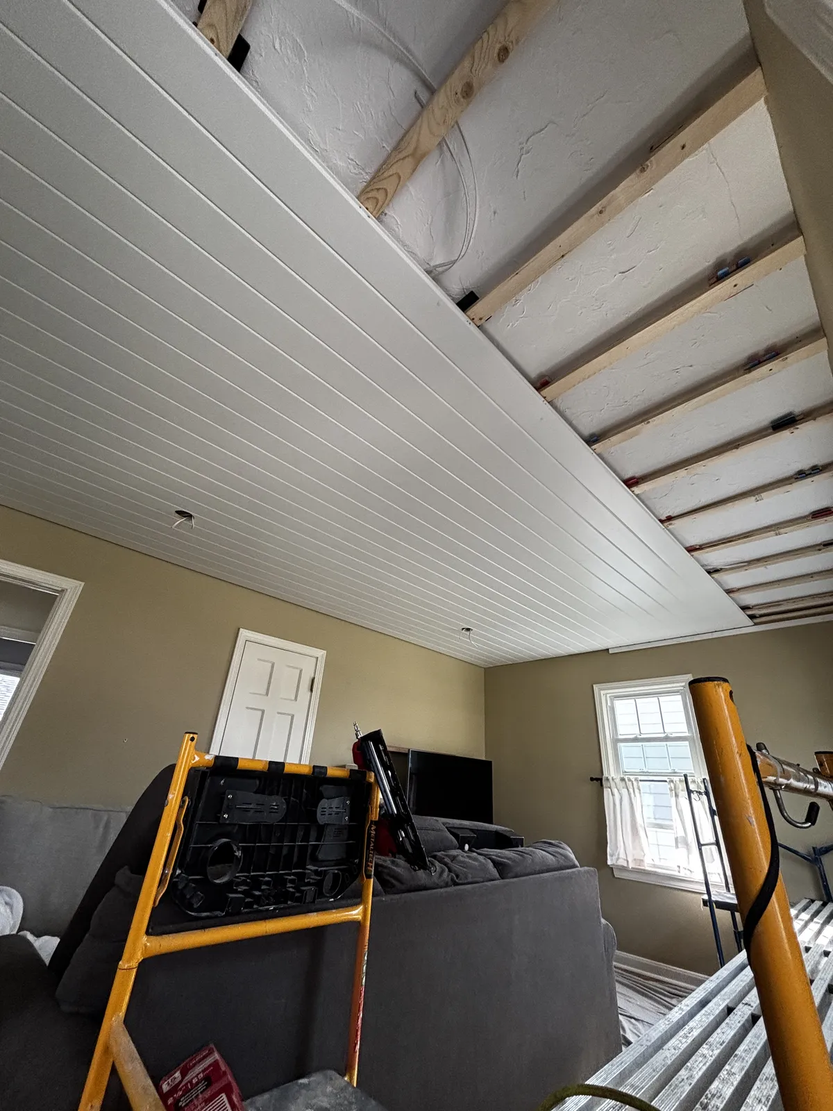 Shiplap ceiling installation in living room